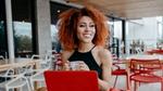 Smiling women with natural curls working on her laptop