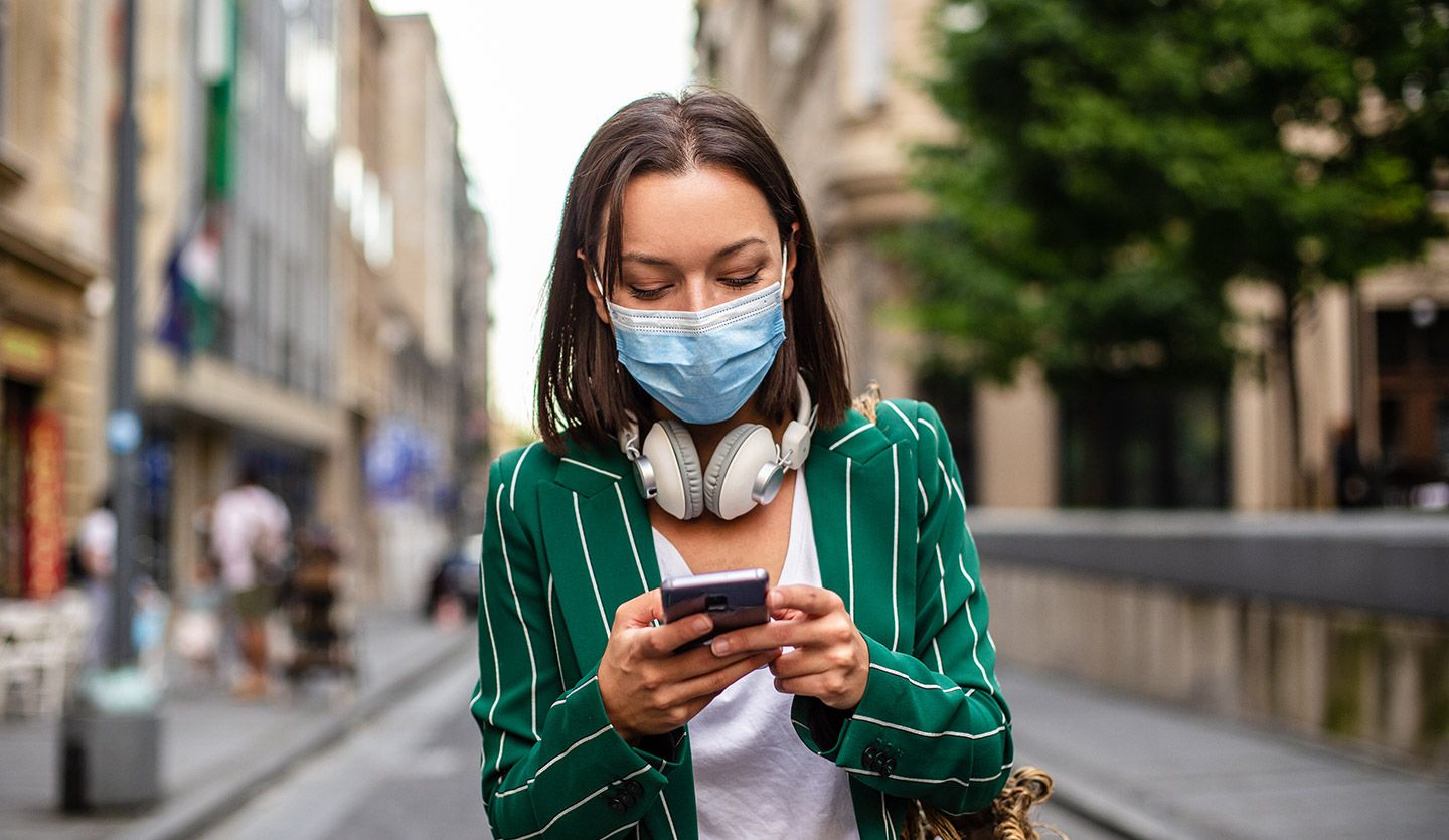 Woman walking in the city and checking her smartphone