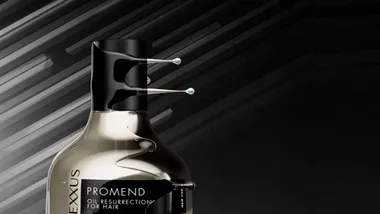 Cropped image of the top half of a gold bottle of Nexxus Promend hair treatment.