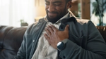 Man pressing hand to chest, grimacing in discomfort.