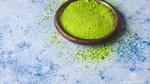 A small bowl of lime green microalgae powder.
