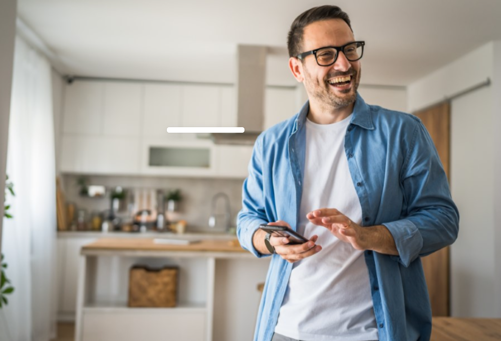 A man with a phone smiling 