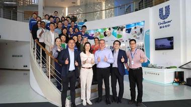 Reginaldo Ecclissato smiling with a team of colleagues on a staircase