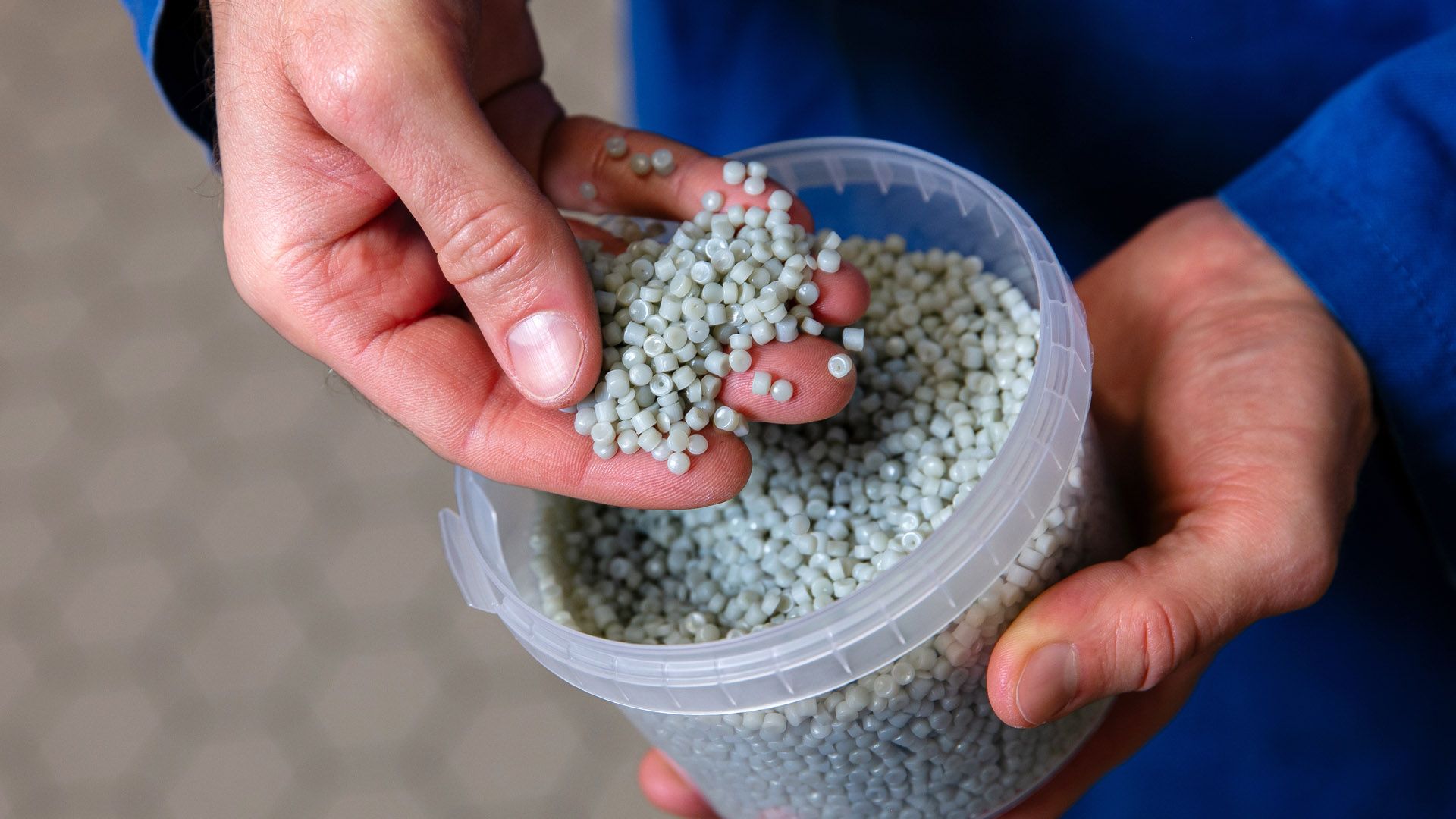 Unilever scientist holding a handful of recycled plastic pellets