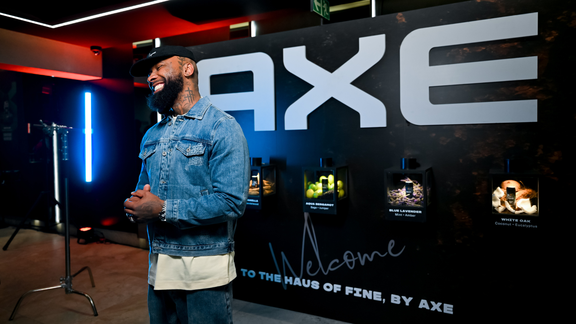 An AXE-branded event space with illuminated displays and fragrance products showcased along a dramatic black backdrop.