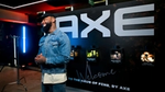An AXE-branded event space with illuminated displays and fragrance products showcased along a dramatic black backdrop.